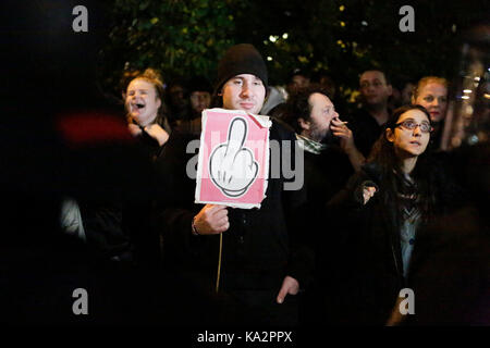 Berlin, Deutschland. 24. September 2017. Eine Demonstrantin hält ein Zeichen dafür, dass die Zeichnung einer Faust, dass der Mittelfinger gibt zeigt. Hunderte von Demonstranten vor einem Club in der Nähe der zentralen Alexanderplatz in Berlin, war der Schauplatz der Wahlnacht Partei des rechten Flügels AfD (Alternative für Deutschland) Partei gesammelt. Sie protestierten gegen den Wahlsieg der Partei, die fast 13 % der Stimmen gewonnen. Der Veranstaltungsort war, wurde von einem Großteil der Riot Polizisten geschützt. Quelle: Michael Debets/Alamy leben Nachrichten Stockfoto