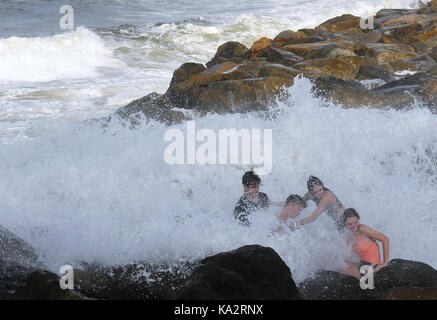 Fouras, United States. 24 Sep, 2017. David Thomas (von L), Colby Savary, Natalie Thomas und Madelyn Miller erhalten von der Brandung wie Wellen über die Felsen am 24. September, 2017 in Fouras, Florida als Hurrikan Maria bis Pflüge der Atlantikküste, hohe Wellen und Rip-Ströme nach einem direkten Treffer in Puerto Rico, so dass die gesamte Insel ohne Strom. Credit: Paul Hennessy/Alamy leben Nachrichten Stockfoto