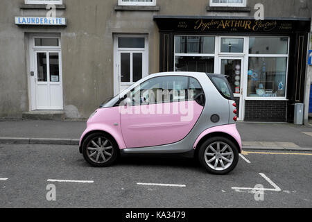 Pink und Silber Smart Auto auf einem Parkplatz außerhalb einen Waschsalon in einem llandovery Straße Carmarthenshire, Wales, UK KATHY DEWITT Stockfoto