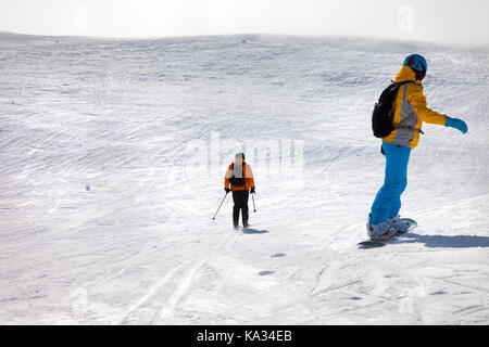 Snowboarder und Skifahrer bergab auf Schnee off-piste-Hang in der Sonne Winter Tag mit Nebel. Kaukasus, Georgien, Region Gudauri. Stockfoto