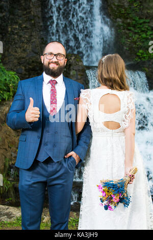 Braut und Bräutigam vor einem Wasserfall Stockfoto