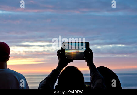 Die Leute, die Fotos von dem schönen Sonnenuntergang mit einem Tablet mobile Device auf der BC-Fähre. BC Ferries Reise durch die Gulf Islands. Stockfoto