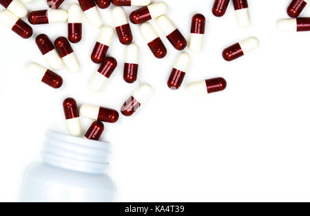 Gießen Antibiotika Kapsel Pillen in die Plastikflasche auf weißem Hintergrund mit Kopie Raum isoliert. Droge, Lagerung, Antibiotikum Drogenkonsum mit angemessenen, Stockfoto