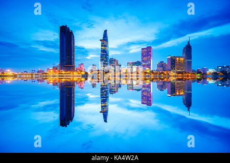 Stadtbild in der Reflexion von Ho Chi Minh Stadt am wunderschönen Dämmerung, über Saigon River gesehen. Hochiminh Stadt ist die größte Stadt in Vietnam. Stockfoto