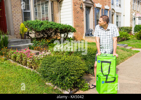 Fairfax, USA - 12. September 2017: Amazon Frisch isolierte Lebensmittel-lieferservice Taschen, Taschen auf der Vorderseite Home Haus Veranda closeup mit jungen Menschen ihnen Kommissionierung u Stockfoto