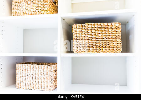 Nahaufnahme von gewebtem Stroh Körbe in modernen, minimalistischen weißen Schrank oder Raum mit hellem Licht in der Inszenierung Modell Haus oder Wohnung Stockfoto