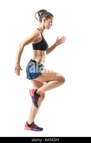 Athletischen weiblichen sprinter Bewegung ausführen und mit Blick auf die Zukunft gerichtet. Voller Körper Länge Porträt auf weißem studio Hintergrund isoliert. Stockfoto