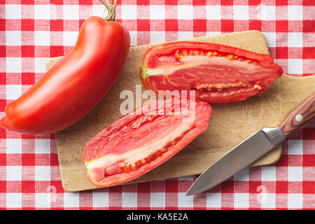 Halbiert San Marzano Tomaten auf Schneidebrett. Ansicht von oben Stockfoto