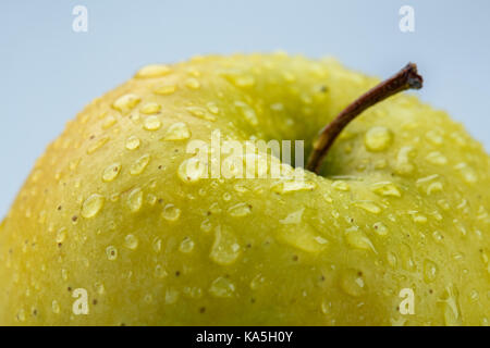 Gelber Apfel Makro mit Wassertropfen bedeckt Stockfoto