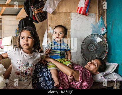 Mutter und ihren zwei Kindern in Holz- Haus ruhenden, Semporna Stockfoto