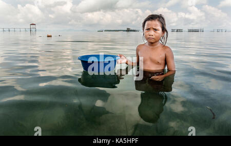 Bajau Stamm kid Fragen für Lebensmittel, Semporna, Malaysia Stockfoto