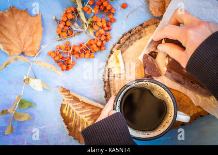 Herbst Kaffee mit Schokolade auf einem blauen Hintergrund, Snack auf der Natur. Stockfoto