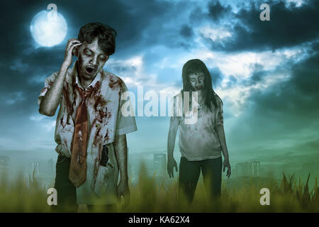 Beängstigend zwei asiatischen Zombies mit Wunde und Mad Ausdruck in der Nacht Stockfoto