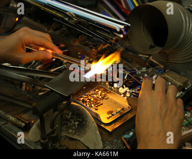 Glaser und dabei das Glas mit einer sehr hohen Temperatur Flamme in seiner handwerklichen Workshop in Italien Stockfoto
