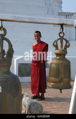 Das tägliche Leben in einem buddhistischen Kloster. Junge fröhlich lachenden Mönch in einem Kloster in der Nähe des heiligen Glocke. Stockfoto