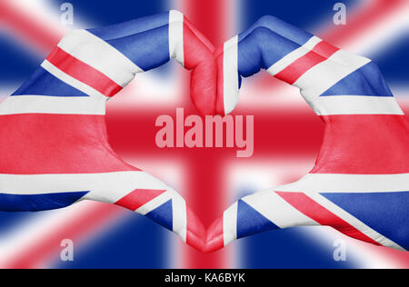 Großbritannien Flagge auf Händen gemalt, ein Herz auf unscharfen Union Jack Hintergrund, UK National und Patriotismus Konzept isoliert Stockfoto