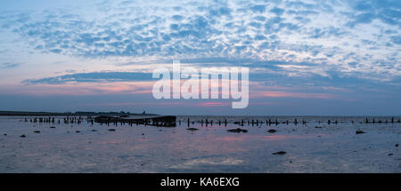 Alte havarierten Boot mit Sonnenuntergang am Wattenmeer, Nordsee Holland. Stockfoto