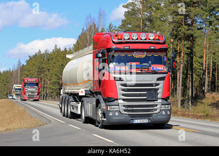 Salo, Finnland - 21 April 2017: Maßgeschneiderte rote Scania R440 semi Tanker führt einen Konvoi von drei polnischen semi Tank-LKW auf der Autobahn an einem sonnigen Tag in Stockfoto