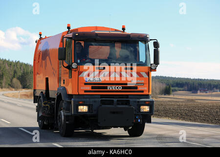 SALO, Finnland - 21 April, 2017: Orange Iveco Eurotech Cursor Kehrmaschine Lkw bewegt sich entlang der Autobahn an der Feder. Stockfoto