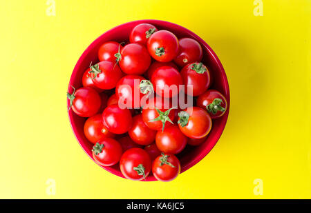 Bündel von Cherry Tomaten in eine Schüssel auf gelbem Hintergrund Stockfoto