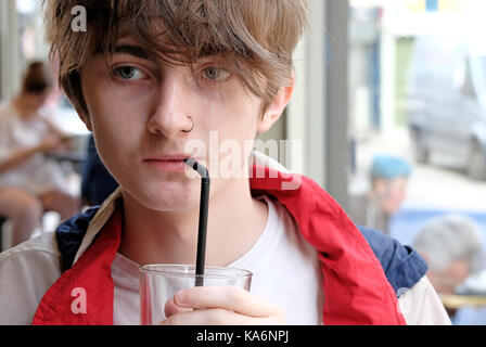 Teenager trinken Getränk aus Stroh im Cafe innen Stockfoto