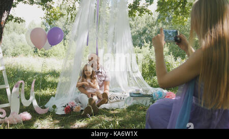Die Familie Picknick im Park - Mutter ein Foto auf einem Mobiltelefon Stockfoto