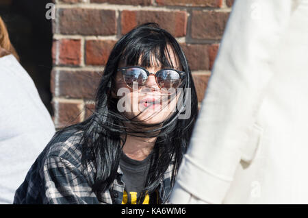 Junge Frau sitzend, für TV mit den Überlegungen der Interviewer in Ihre Brille interviewt. Stockfoto