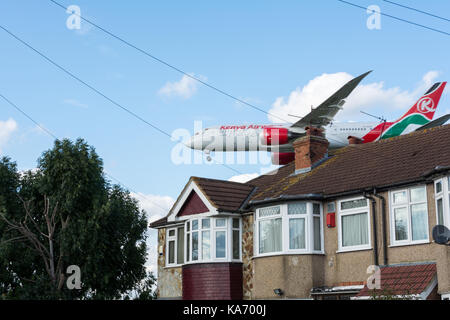 Ein tief fliegenden Kenya Airways Flugzeug in das Land über Myrtle Avenue am Flughafen Heathrow, London, Großbritannien Stockfoto