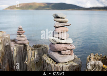 Kiesel Türmen auf Holz- Beiträge auf porlock Strand, England gebaut Stockfoto