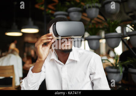 Afrikanische Mann mit Brille in der virtuellen Realität Ansehen von Videos. Stockfoto