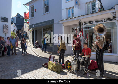 Straßenkünstler - die Straßenkünstler und Gaukler Swervy Welt spielen im Zentrum von St Ives in Cornwall. Stockfoto