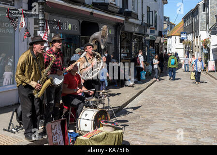 Straßenkünstler - die Straßenkünstler und Gaukler Swervy Welt spielen im Zentrum von St Ives in Cornwall. Stockfoto