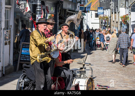 Straßenkünstler - die Straßenkünstler und Gaukler Swervy Welt spielen im Zentrum von St Ives in Cornwall. Stockfoto