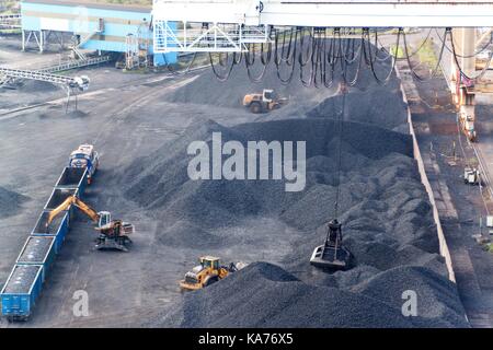 Im Hafen Kohle Umschlagterminal. Kohle entladen von Wagen mit speziellen Kranen. Arbeiten in einem Hafen in der Nähe der Ostsee. Stockfoto