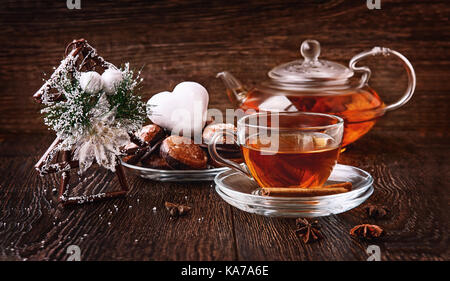 Heißen Tee über Weihnachten in Glas transparent Tasse mit Kaffee-, Baum- und Lebkuchen, Zimt und Vanille. Die horizontale Rahmen. Stockfoto
