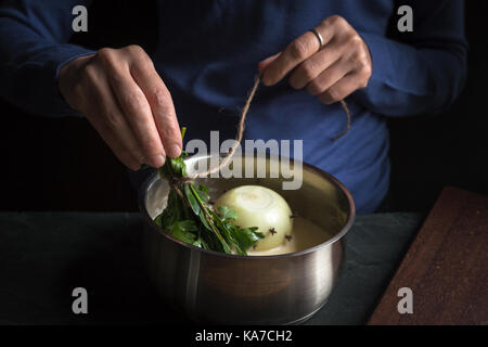 Vorbereitung der Béchamelsoße Sauce, Blumenstrauß aus Beilagen in den Händen horizontal Stockfoto