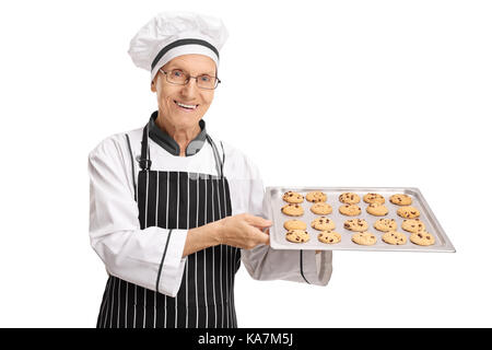 Ältere baker Holding ein Fach mit frisch gebackenen Cookies auf weißem Hintergrund Stockfoto