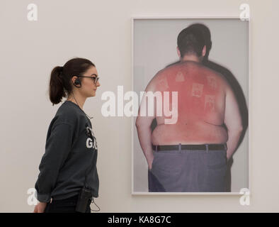 Saatchi Gallery, London, Großbritannien. 26 Sep, 2017. Die Saatchi Gallery Herbst zeigen Ikonoklasten: Kunst aus dem Mainstream öffnet am 27. September 2017, genau 20 Jahre nach Charles Saatchi Ära definieren Ausstellung Sensation, die am 18. September 1997 eröffnet, die Einleitung der Karrieren von Tracey Emin & Damien Hirst. Ikonoklasten untersucht die Arbeit von 13 bahnbrechende britische und internationale Künstlerinnen und Künstler, deren Bild Entscheidungspraxis unorthodox ist. Ein Mitglied der Galerie Personal untersucht Thomas Mailaender, Illustrierte Menschen Nr. 14, 2014. Credit: Malcolm Park/Alamy Leben Nachrichten. Stockfoto