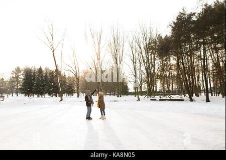 Älteres Paar im sonnigen Winter Natur Eiskunstlauf. Stockfoto