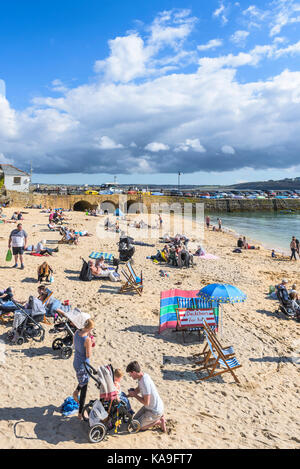 St Ives - Urlauber entspannen auf St Ives Harbour Beach in St Ives Cornwall. Stockfoto