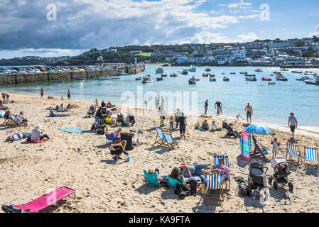 St Ives - Urlauber entspannen auf St Ives Harbour Beach in St Ives Cornwall. Stockfoto