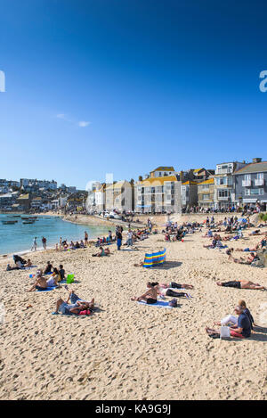 St Ives - Urlauber entspannen auf St Ives Harbour Beach in Cornwall. Stockfoto