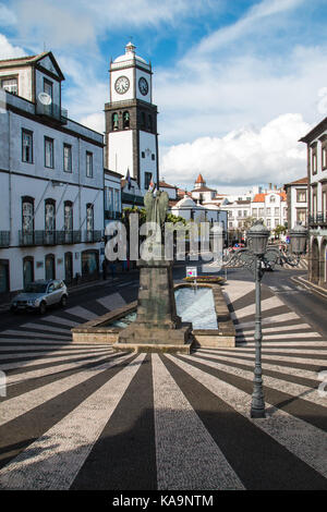Strahlen der Stein auf den gepflasterten Platz mit einer Kirche und die Statue. Ponta Delgada, Sao Miguel, Azoren, Portugal. Stockfoto