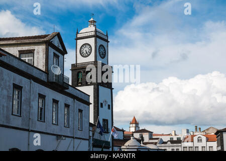 Turm einer Kirche an einem Platz in Ponta Delgada, Sao Miguel, Azoren, Portugal. Dach der Häuser. Intensive Wolken am Himmel. Stockfoto