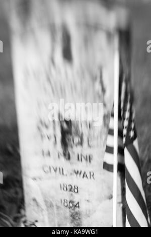 Eine amerikanische Flagge steht neben einem alten Civl Krieg Grabstein in Rahway Friedhof in New Jersey. Eine spezielle Linse wurde verwendet, um die verschwommen Effekt zu produzieren. Stockfoto