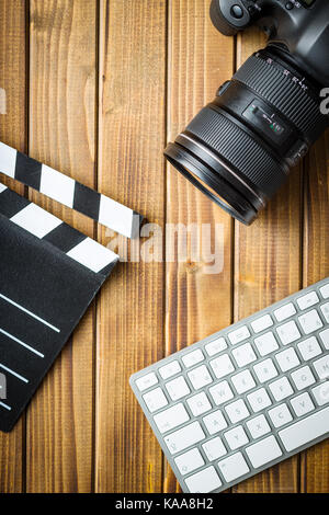 Professionelle Kamera, Computer Tastatur und Klappe auf hölzernen Tisch. Stockfoto