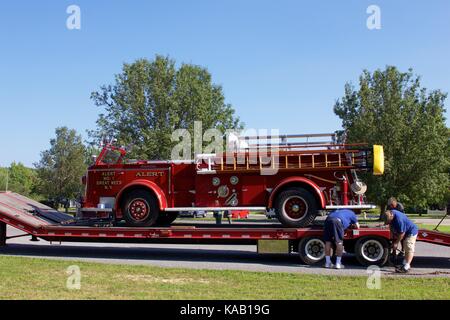 Einige der historischen Löschfahrzeuge werden per Tieflader in die Muster transportiert. Stockfoto