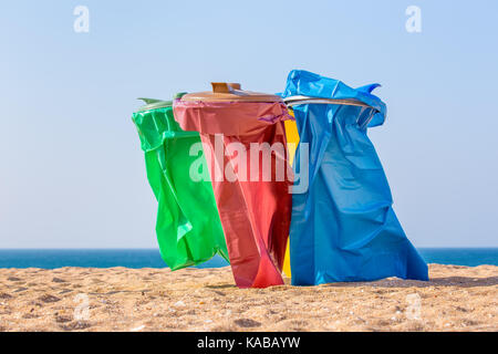 Bunte Müllsäcke am Strand mit Blick aufs Meer Stockfoto