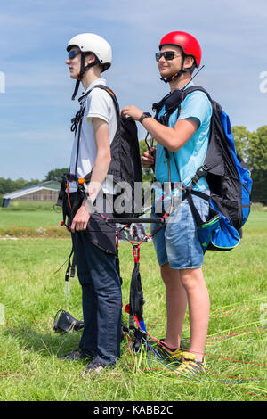 Paragliding Kursleiter mit Junge vorbereiten für Tandemflug Stockfoto