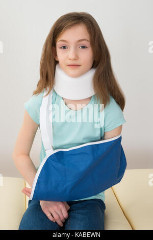 Portrait von Mädchen mit Neck Brace und Arm Schlinge Stockfoto